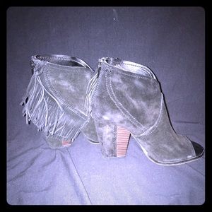 Heeled black booties with tassels on the side